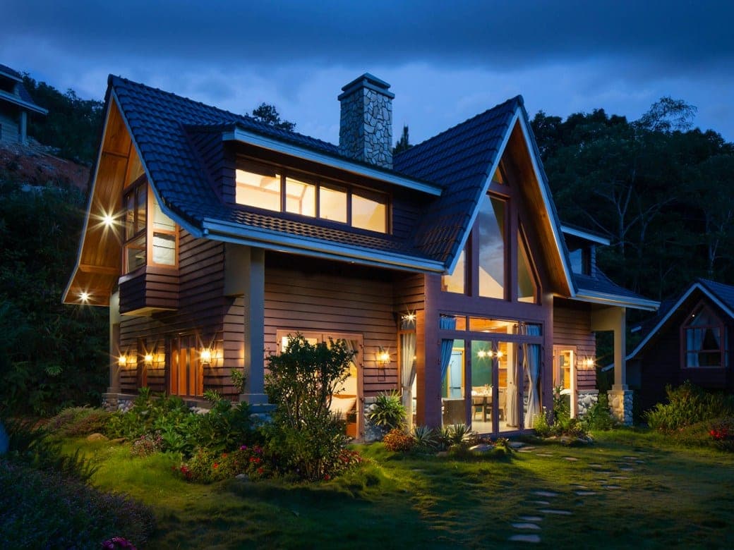 A house at dusk, its windows lit